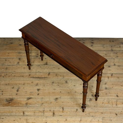fig 2. An antique dark mahogany hall table featuring a single central drawer with a round knob handle and four slender turned legs.
