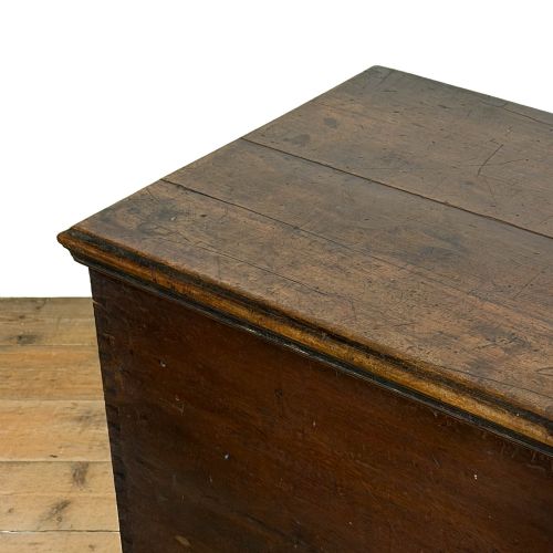 fig 2. A large dark brown oak blanket box featuring a flat hinged lid, visible dovetail joinery, side drop handles, and a central keyhole.
