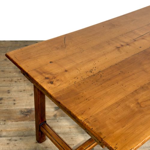 fig 1. An antique fruitwood refectory dining table featuring a rectangular plank top, an extended slide-out leaf, square legs, and lower H-stretchers.