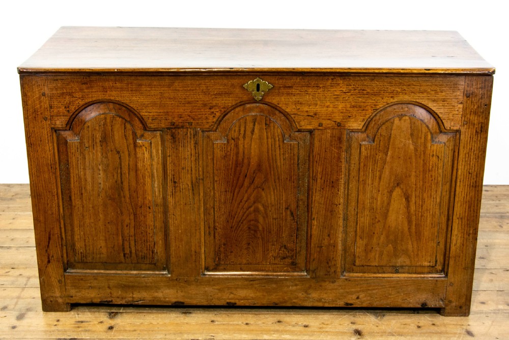 An eighteenth-century Welsh oak coffer featuring three arched raised front panels and a central brass keyhole escutcheon. View II