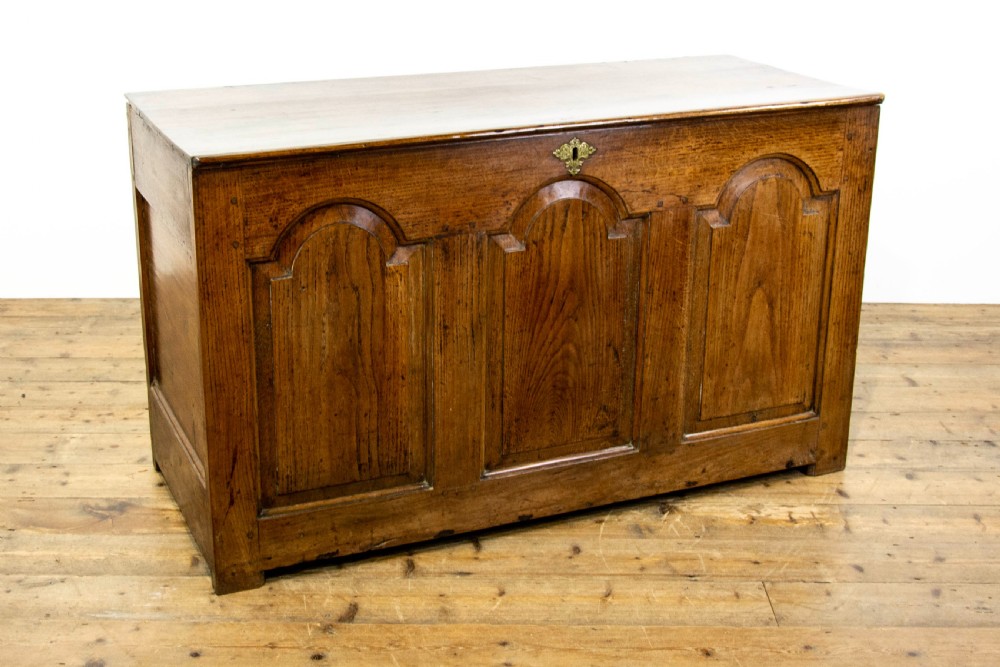 An eighteenth-century Welsh oak coffer featuring three arched raised front panels and a central brass keyhole escutcheon. View III