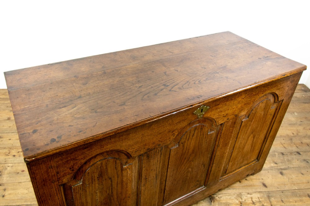 An eighteenth-century Welsh oak coffer featuring three arched raised front panels and a central brass keyhole escutcheon. View IV