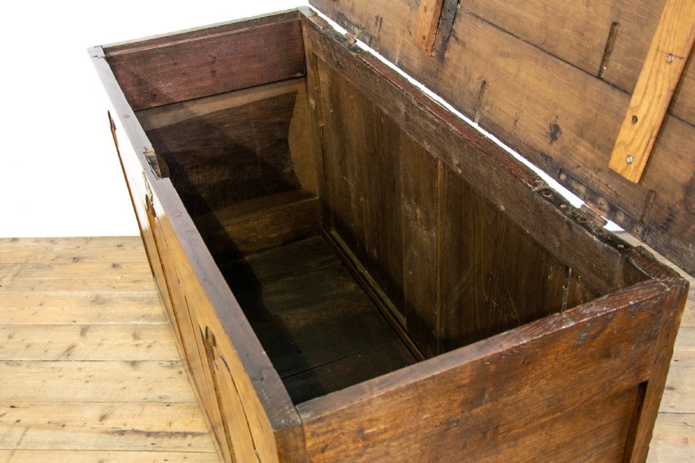 An eighteenth-century Welsh oak coffer featuring three arched raised front panels and a central brass keyhole escutcheon. View IX