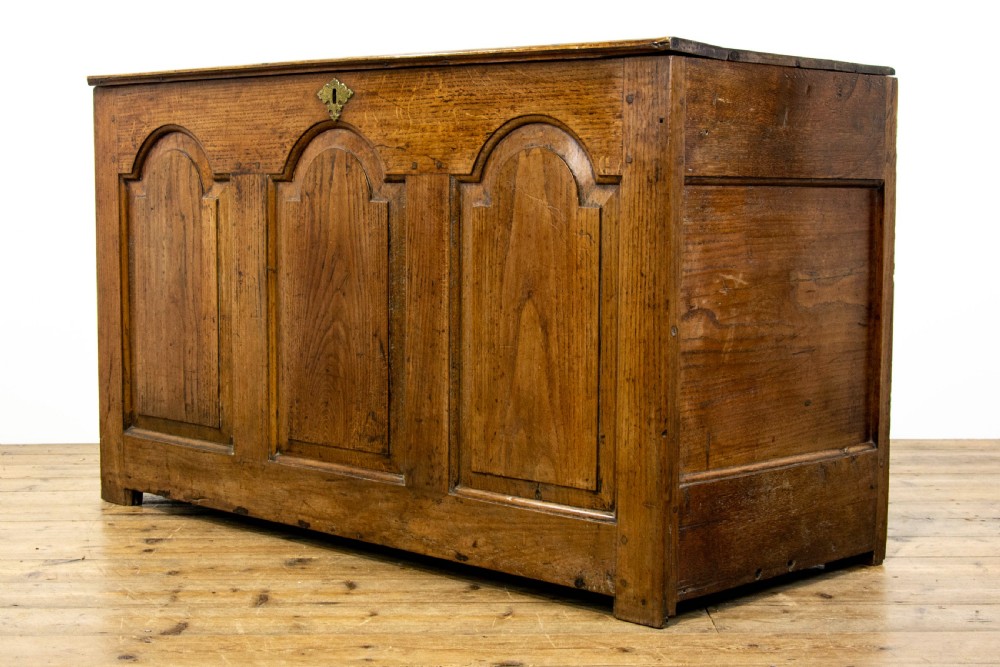 An eighteenth-century Welsh oak coffer featuring three arched raised front panels and a central brass keyhole escutcheon. View XI
