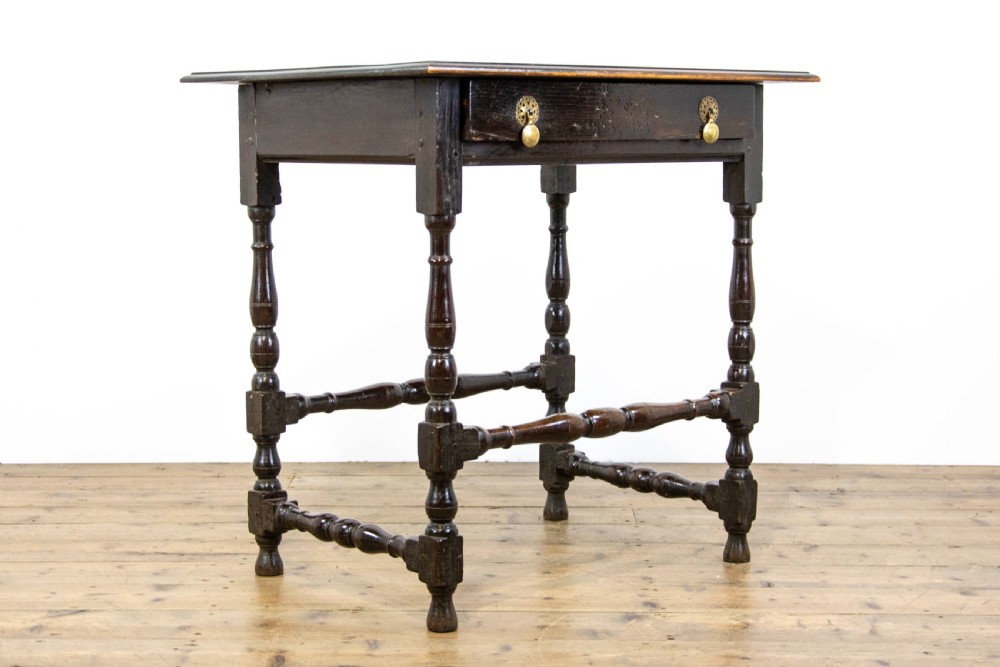 A dark elm side table featuring turned legs, horizontal turned stretchers, and a single drawer with brass drop handles. View V