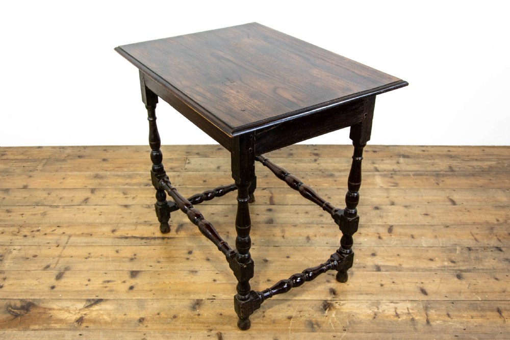 A dark elm side table featuring turned legs, horizontal turned stretchers, and a single drawer with brass drop handles. View IX