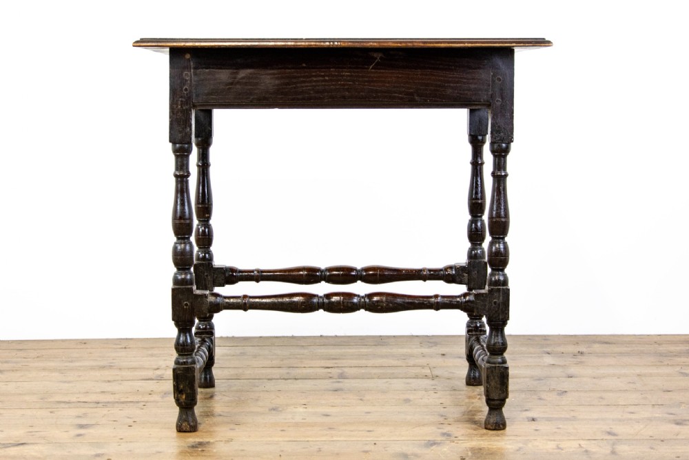 A dark elm side table featuring turned legs, horizontal turned stretchers, and a single drawer with brass drop handles. View X