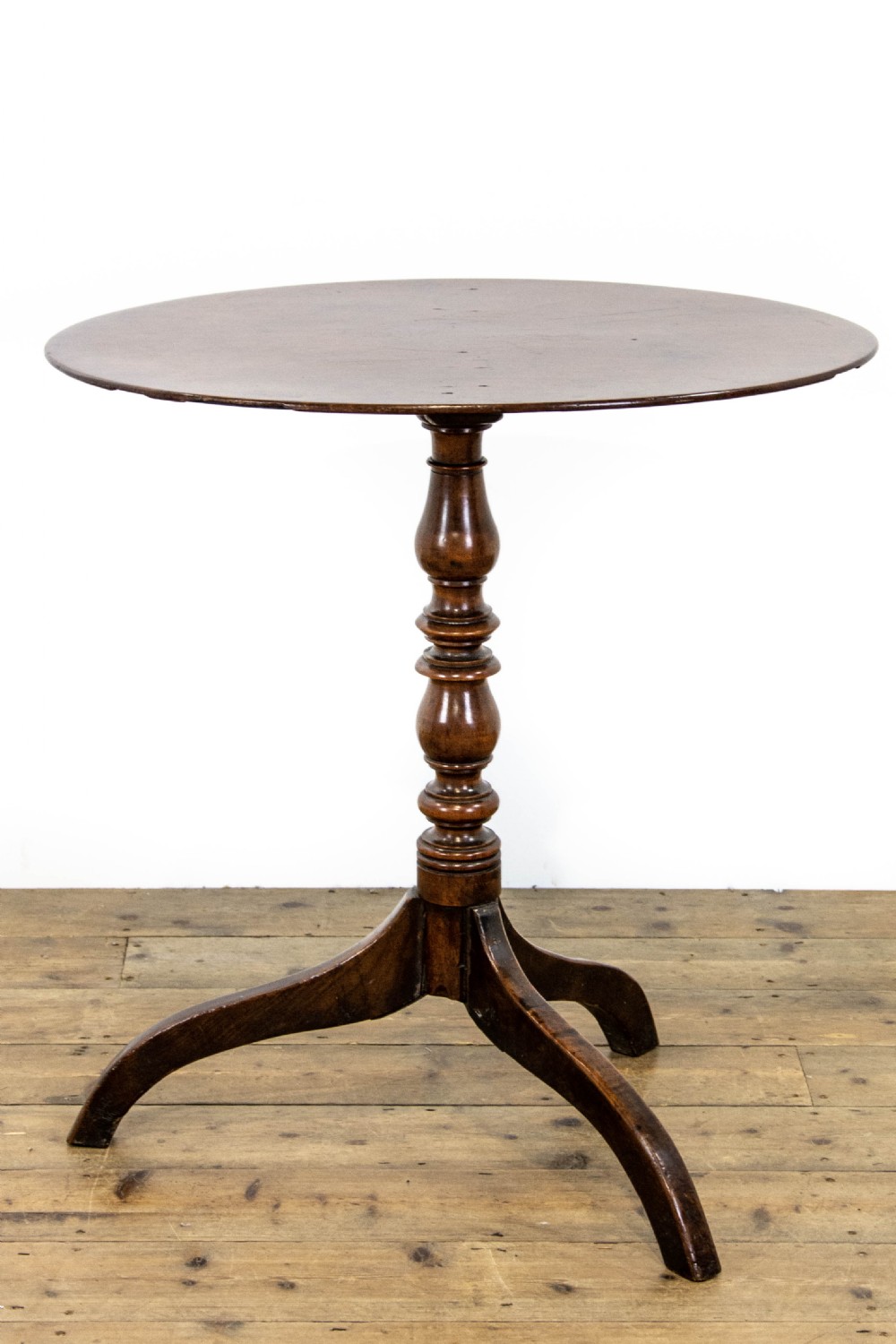 An antique mahogany side table featuring an oval top supported by a turned central pedestal and three curved tripod legs. View III