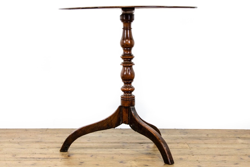 An antique mahogany side table featuring an oval top supported by a turned central pedestal and three curved tripod legs. View IV