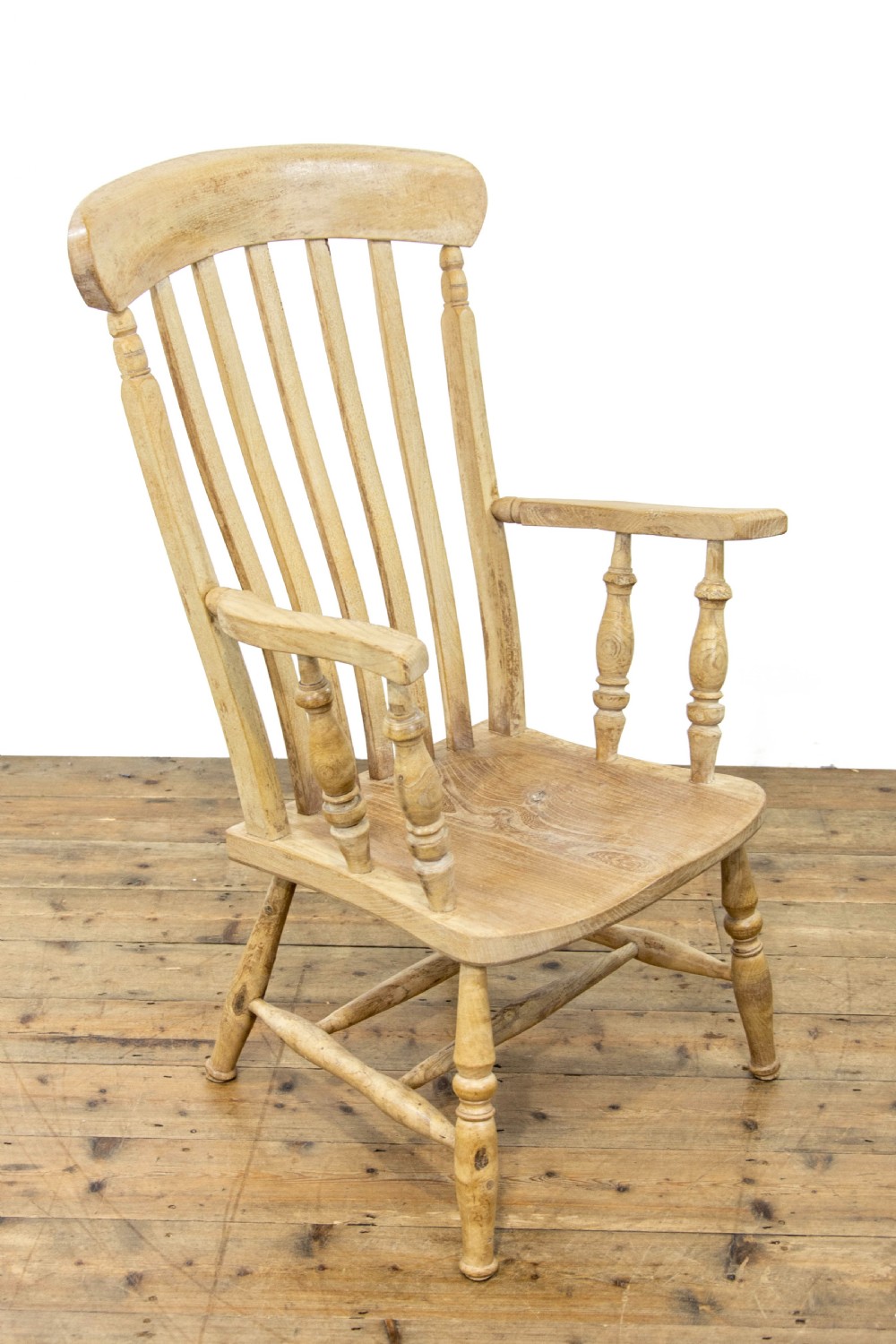 A light ash and elm antique Windsor armchair featuring a spindle backrest, turned legs, and a solid shaped wooden seat. View III