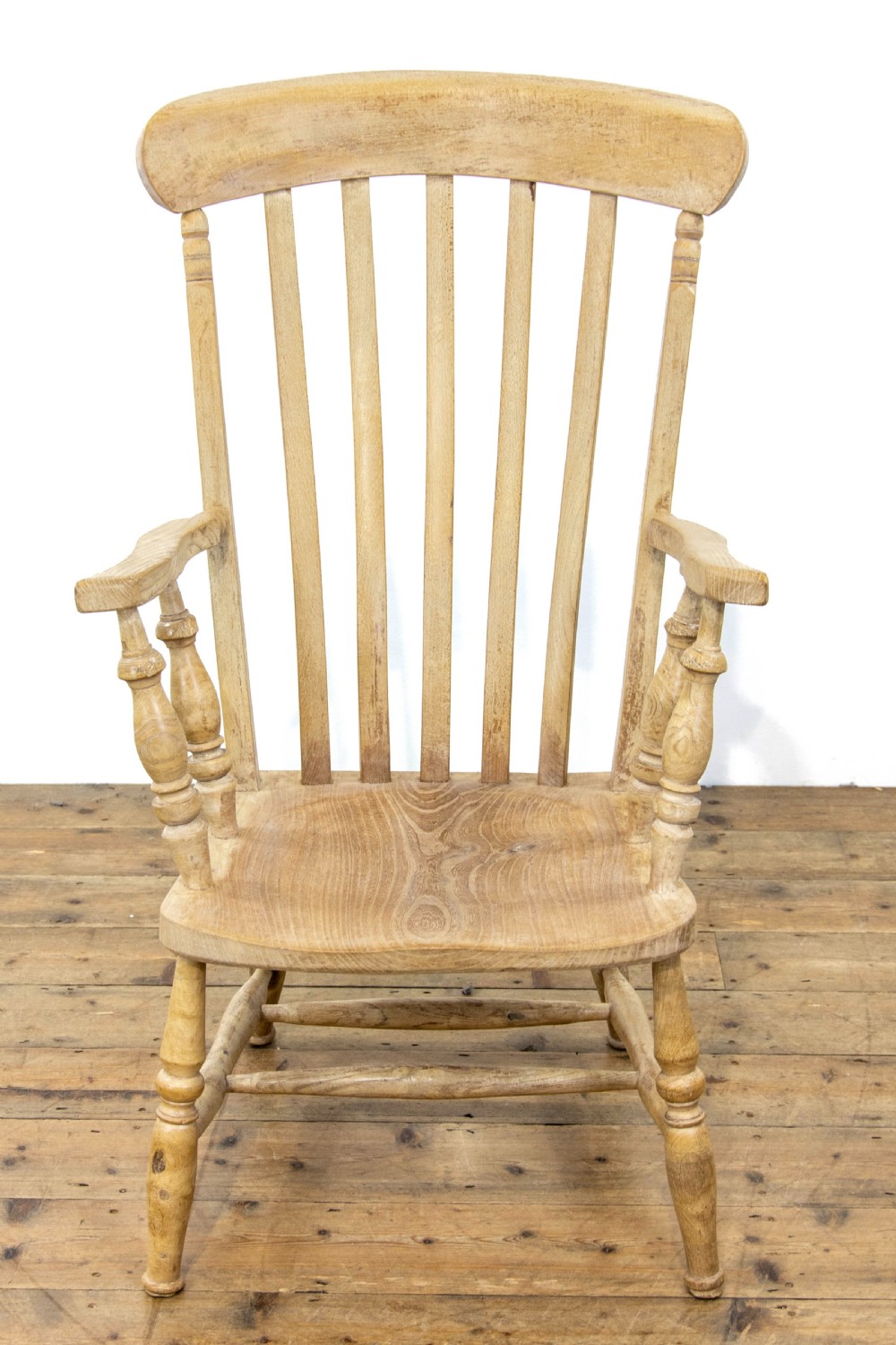 A light ash and elm antique Windsor armchair featuring a spindle backrest, turned legs, and a solid shaped wooden seat. View IV