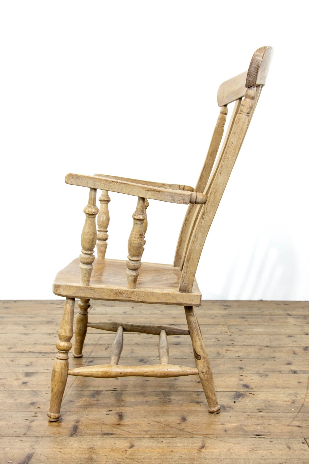 A light ash and elm antique Windsor armchair featuring a spindle backrest, turned legs, and a solid shaped wooden seat. View VI