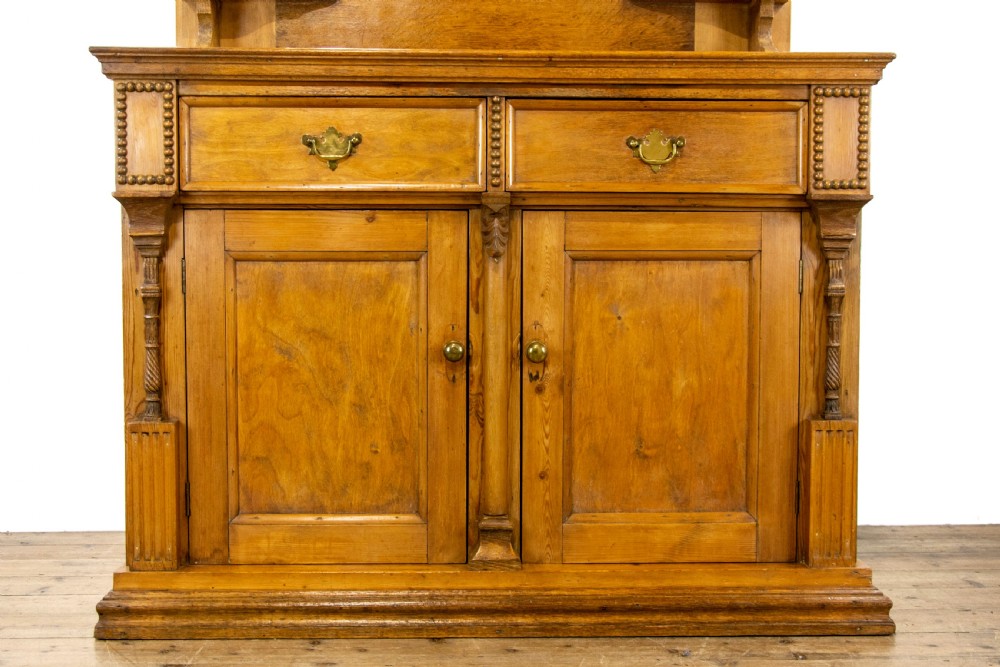 A light oak and pine sideboard featuring a raised mirror back with turned columns, two upper drawers, and a two-door lower cupboard. View III