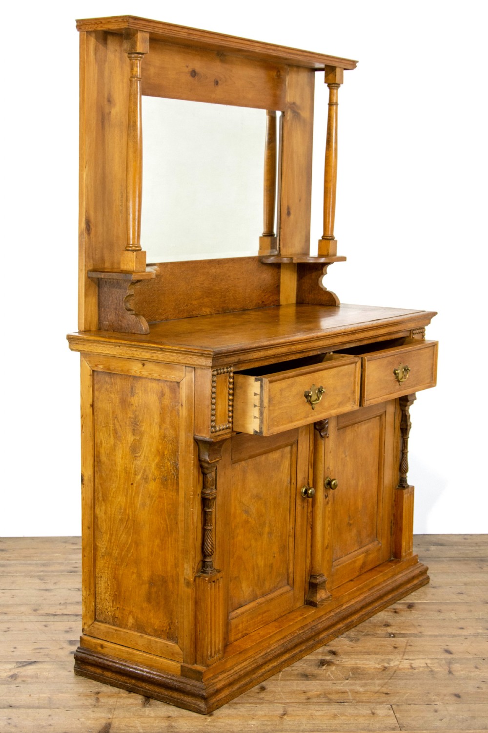 A light oak and pine sideboard featuring a raised mirror back with turned columns, two upper drawers, and a two-door lower cupboard. View VIII