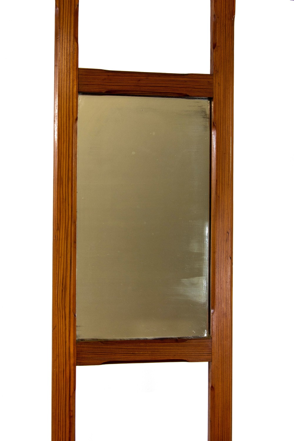 A tall Victorian pitch pine hall stand featuring a central mirror, brass coat hooks, a small drawer unit, and integrated umbrella racks with drip trays. View V