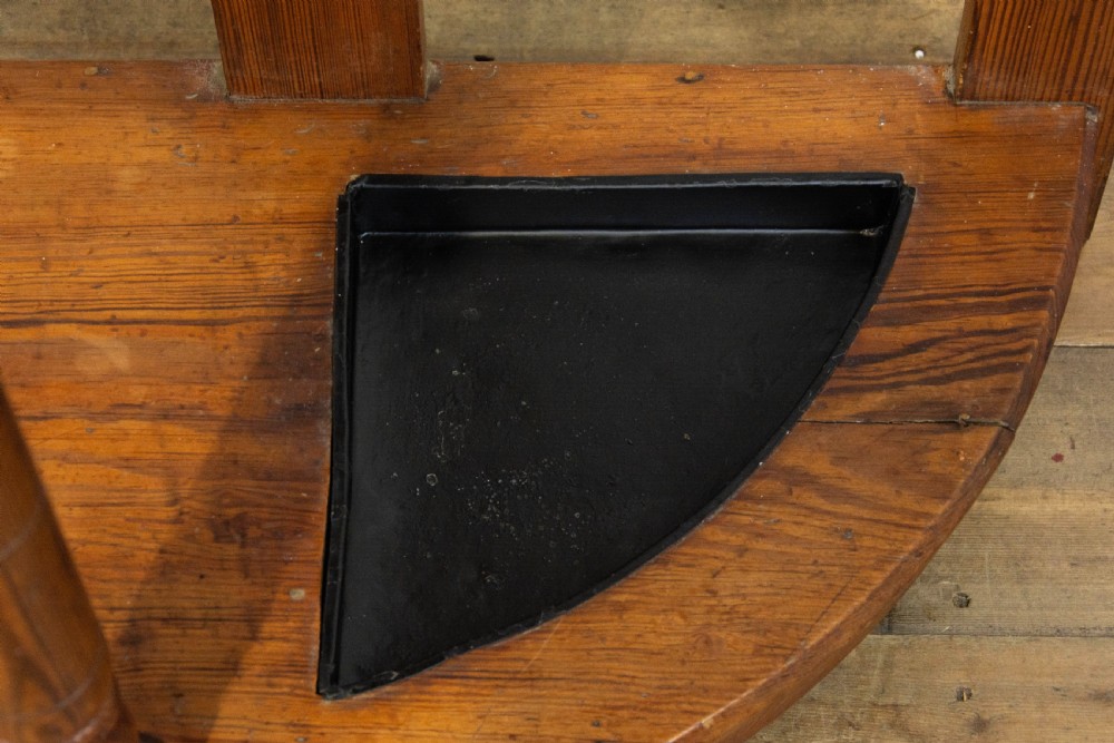 A tall Victorian pitch pine hall stand featuring a central mirror, brass coat hooks, a small drawer unit, and integrated umbrella racks with drip trays. View VIII