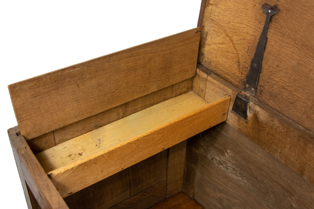 An antique dark oak mule chest featuring three recessed front panels, two lower drawers with brass swan-neck handles, and bracket feet. View XI