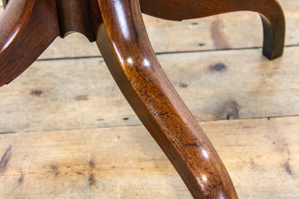 A 19th-century dark mahogany side table featuring a rounded rectangular top supported by a central turned pedestal stem and three down-curved legs. View IX