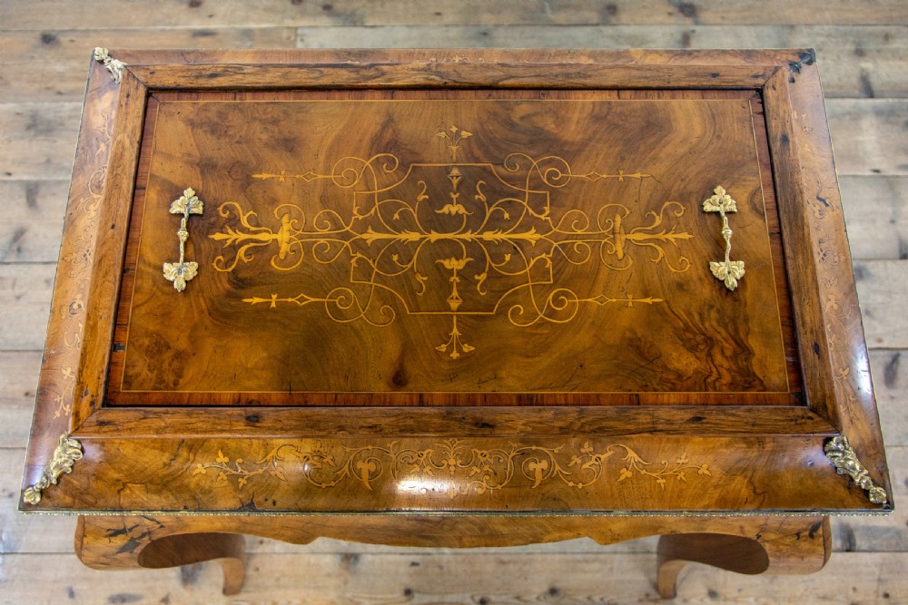 An antique French Rococo style burr walnut jardiniere table with decorative marquetry inlay on the lid, brass mounts, and slender cabriole legs. View V