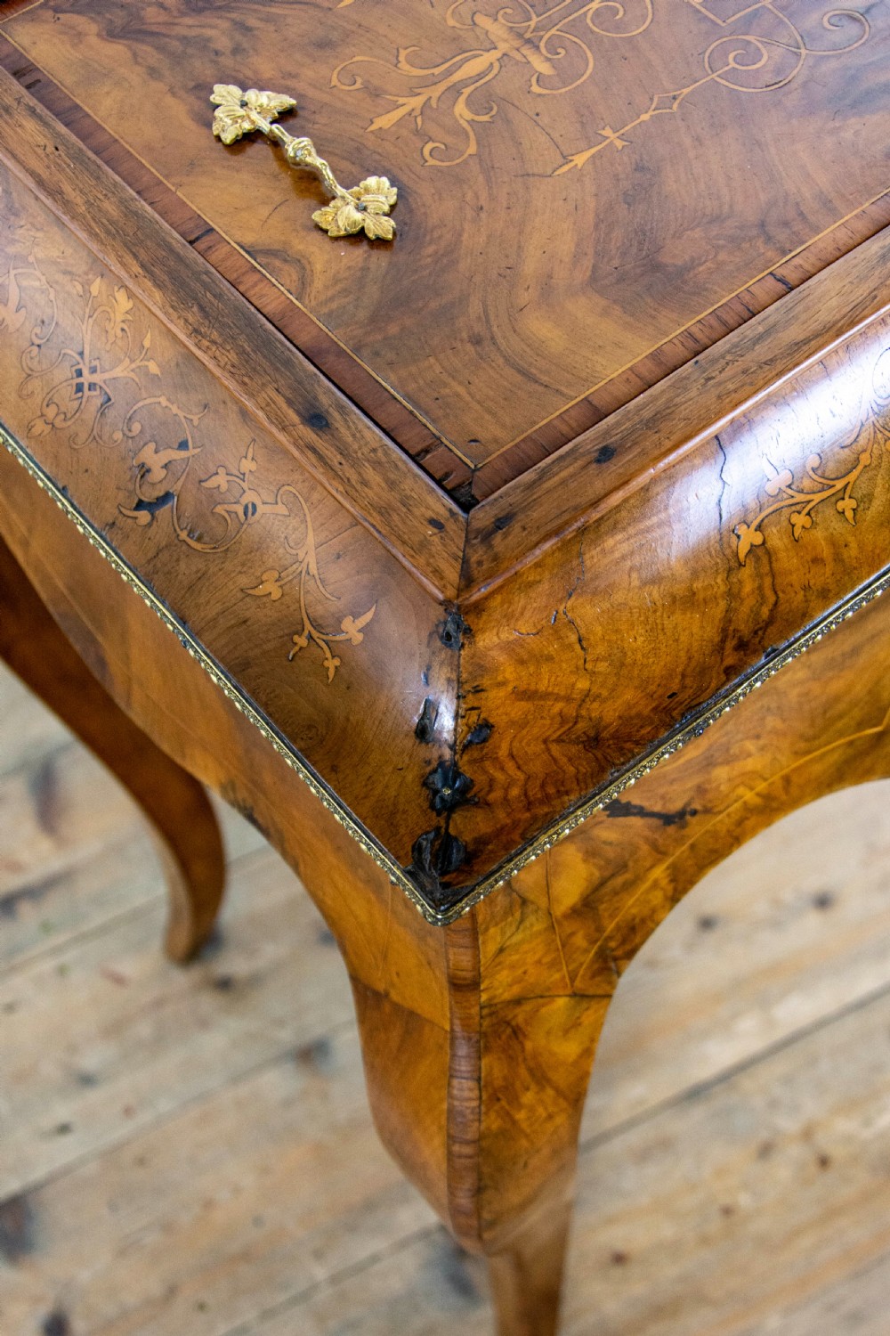 An antique French Rococo style burr walnut jardiniere table with decorative marquetry inlay on the lid, brass mounts, and slender cabriole legs. View VIII