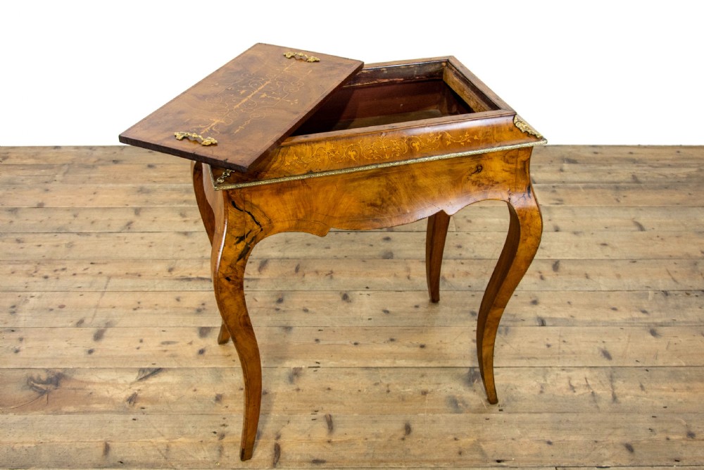 An antique French Rococo style burr walnut jardiniere table with decorative marquetry inlay on the lid, brass mounts, and slender cabriole legs. View IX
