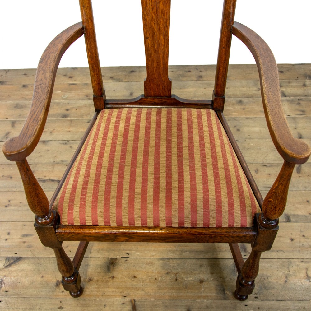 A pair of antique oak armchairs featuring shaped splat backs, curved armrests, turned legs, and red striped upholstered seats. View VI