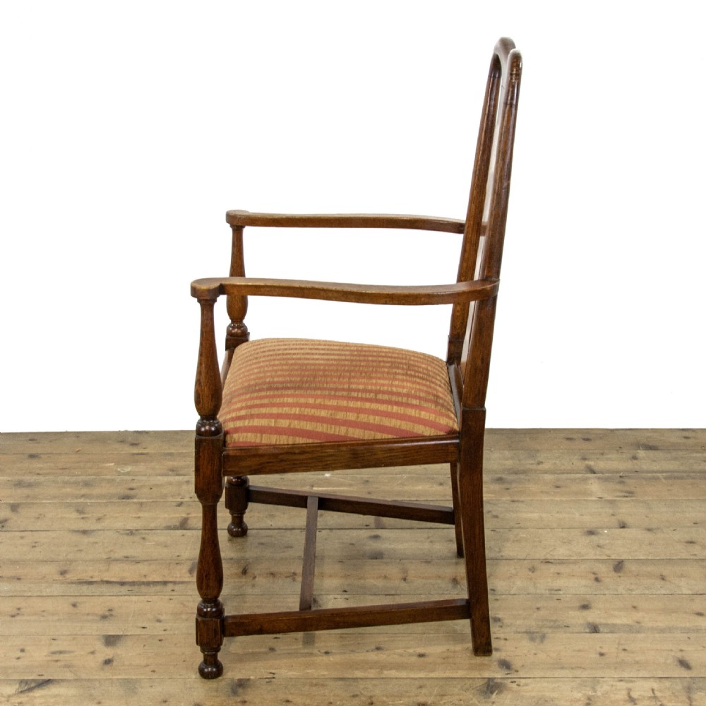 A pair of antique oak armchairs featuring shaped splat backs, curved armrests, turned legs, and red striped upholstered seats. View X