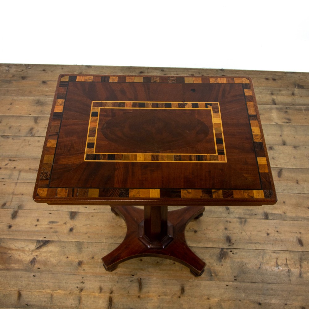 A dark brown mahogany side table featuring a rectangular top with geometric timber inlay, a central octagonal column, and a four-pointed pedestal base. View III