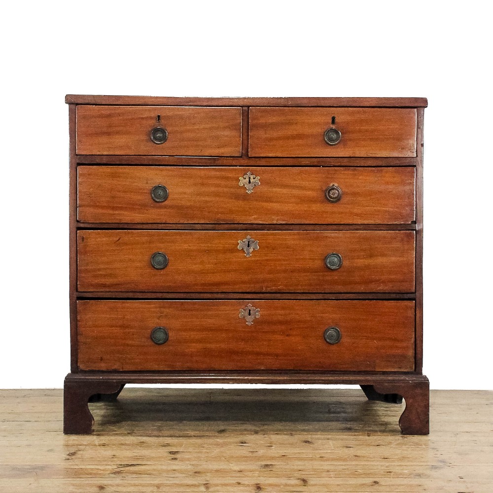 An antique 19th-century mahogany chest of drawers featuring two short over three long graduated drawers with brass hardware and bracket feet.