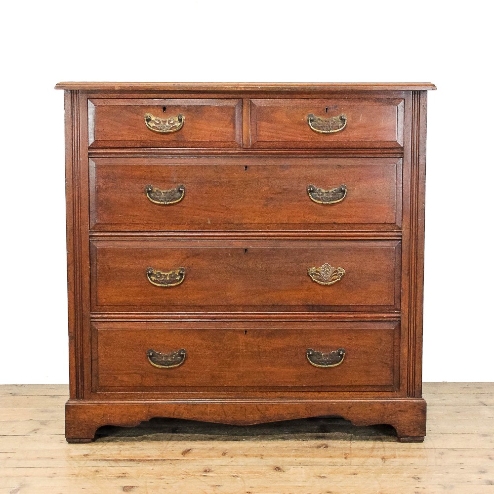 An antique mahogany chest featuring two short drawers above three full-width drawers, styled with decorative brass drop handles and a bracket foot plinth base.