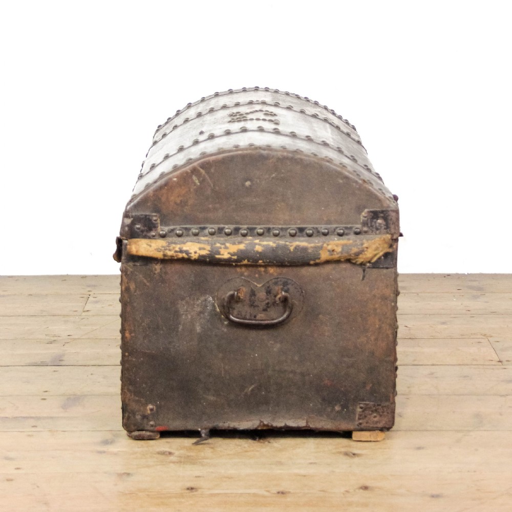 An antique dark brown leather domed trunk decorated with metal studs and initials on the curved lid. View III