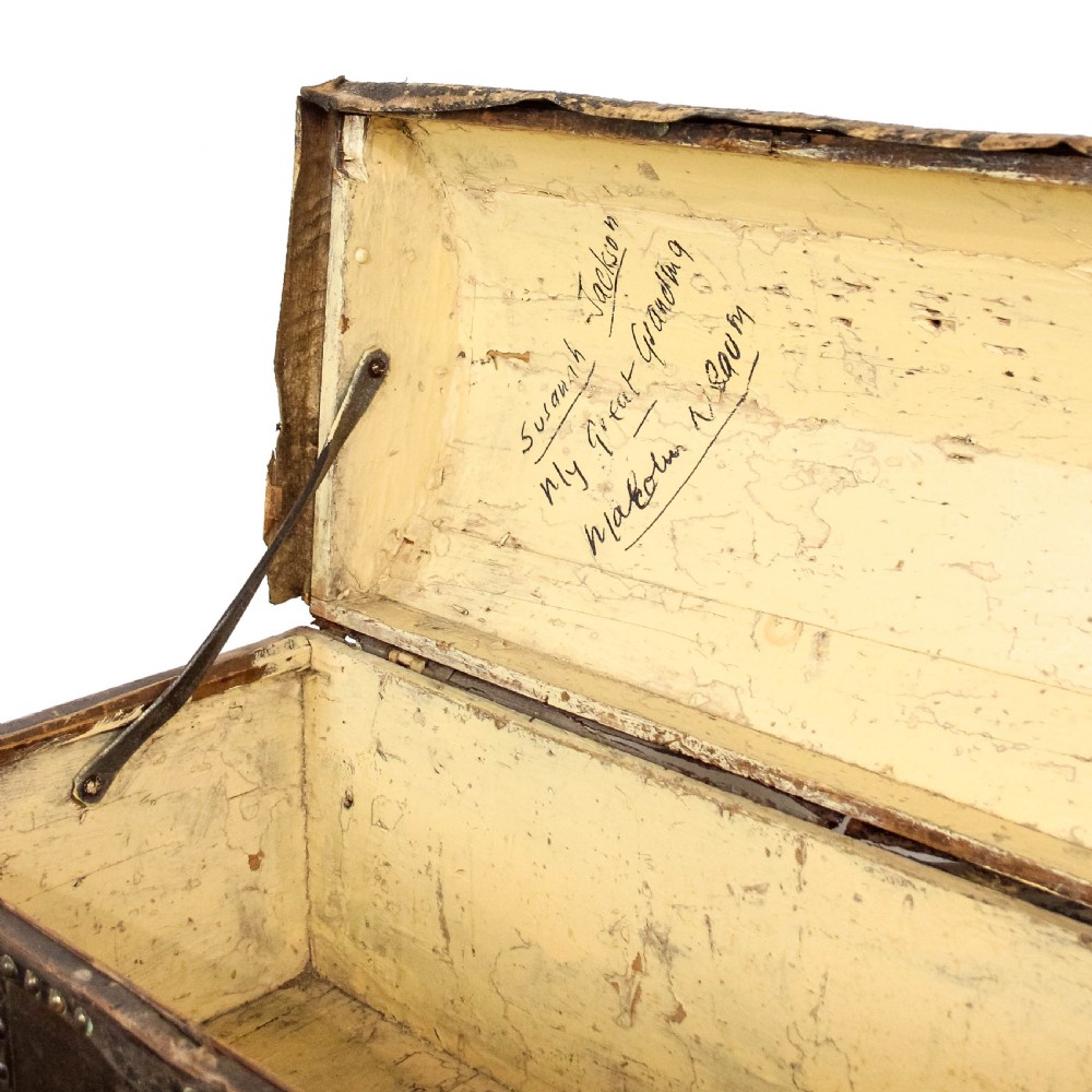 An antique dark brown leather domed trunk decorated with metal studs and initials on the curved lid. View VIII