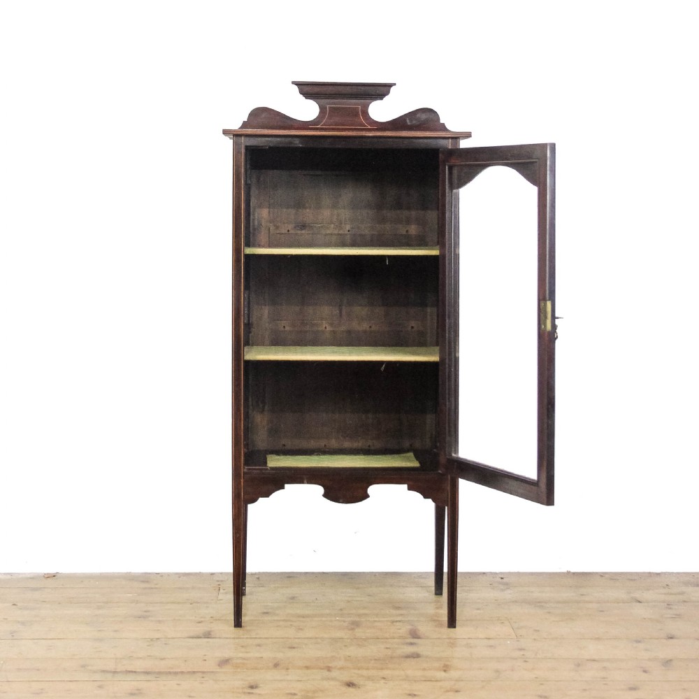 An Edwardian dark mahogany single door display cabinet featuring delicate satinwood inlay, fan corner marquetry, a shaped pediment, and square tapered legs. View III