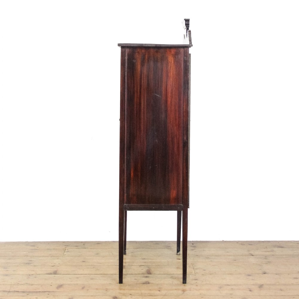 An Edwardian dark mahogany single door display cabinet featuring delicate satinwood inlay, fan corner marquetry, a shaped pediment, and square tapered legs. View VII