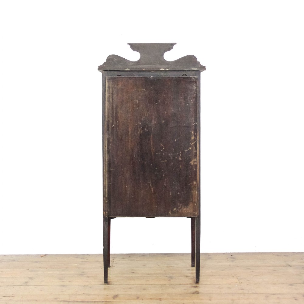 An Edwardian dark mahogany single door display cabinet featuring delicate satinwood inlay, fan corner marquetry, a shaped pediment, and square tapered legs. View IX