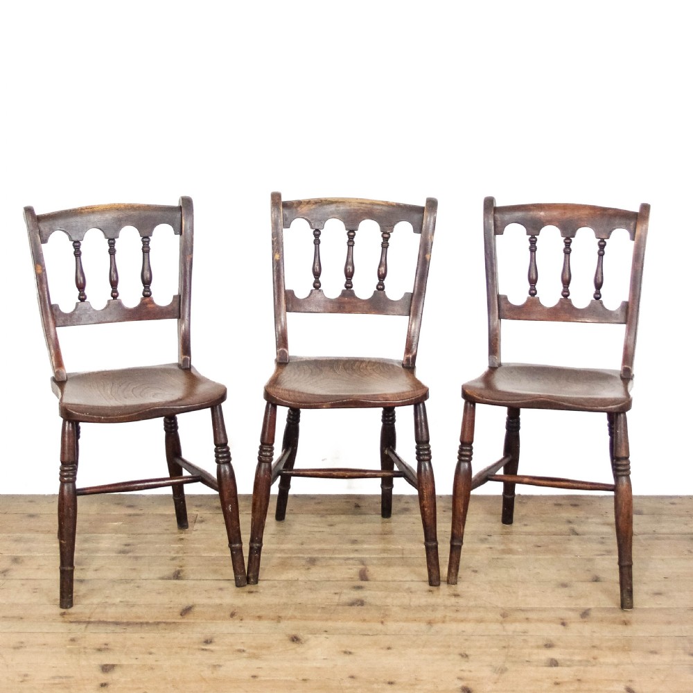 A set of three Victorian elm farmhouse dining chairs featuring shaped seats, turned spindles, and dark timber finishes. View II