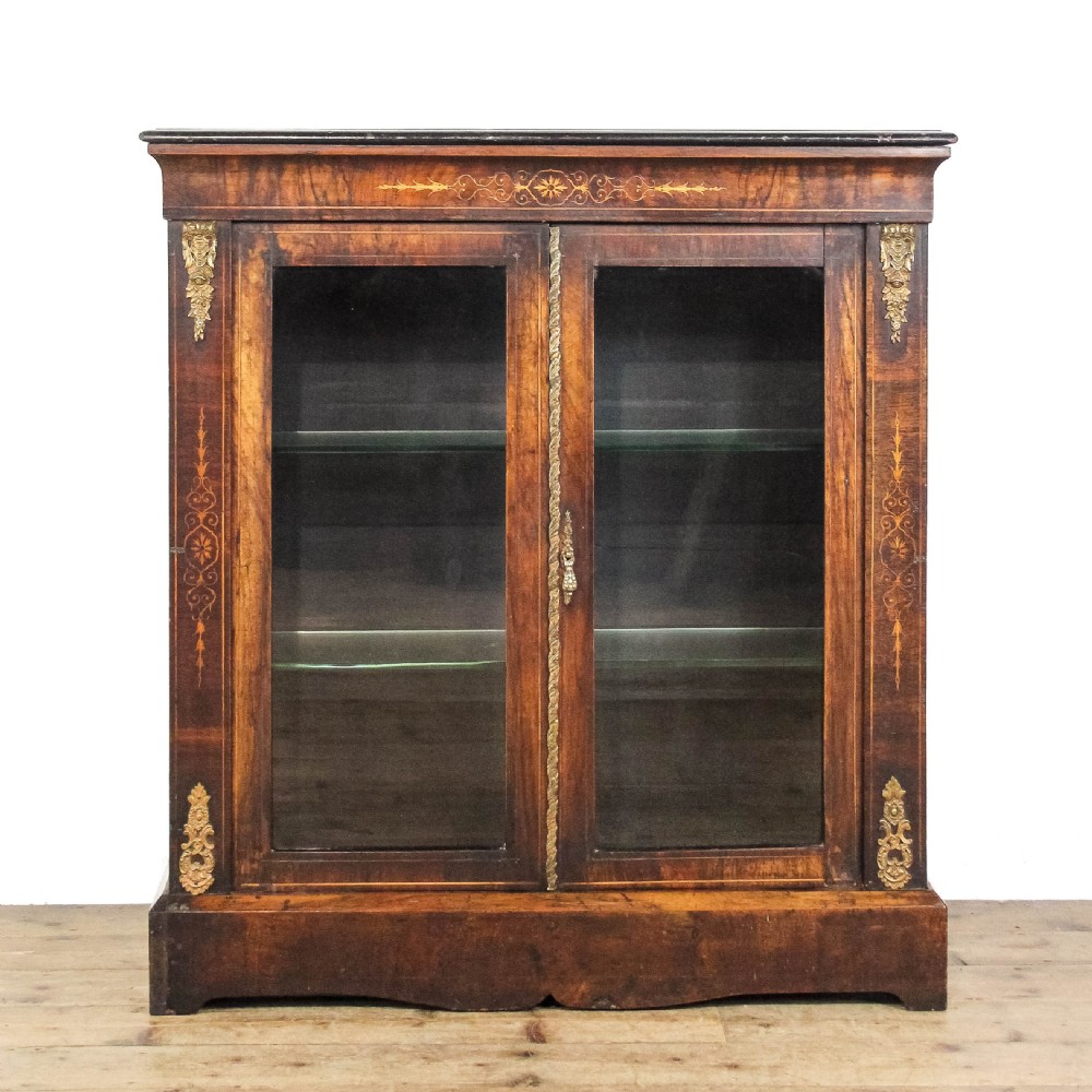An antique Victorian walnut pier cabinet featuring twin glazed doors, floral boxwood marquetry inlay, and decorative ormolu brass mounts.