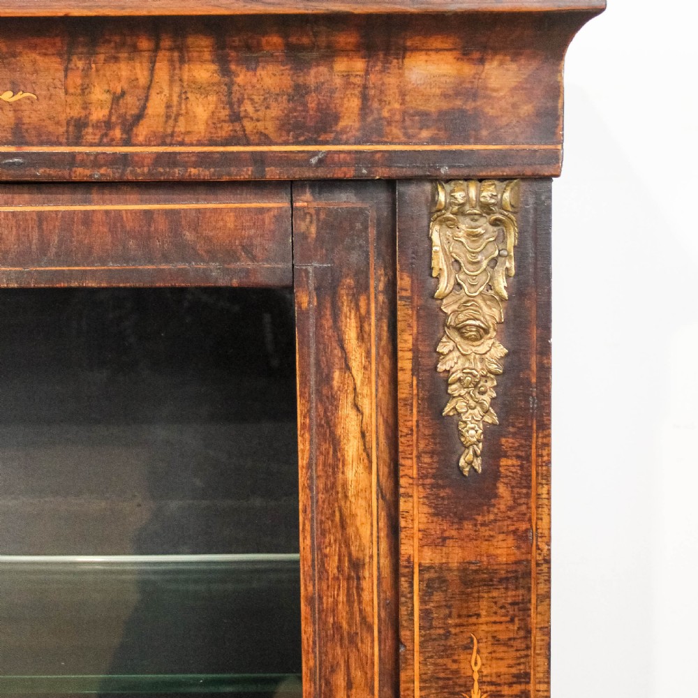 An antique Victorian walnut pier cabinet featuring twin glazed doors, floral boxwood marquetry inlay, and decorative ormolu brass mounts. View II