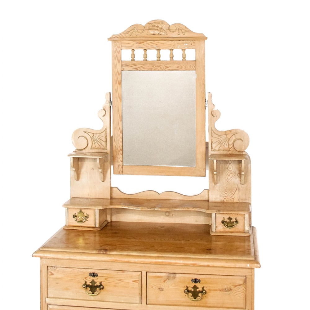 An antique pine dressing chest featuring an upper swivel mirror, small gallery drawers, two short drawers over two long drawers, and turned feet. View II
