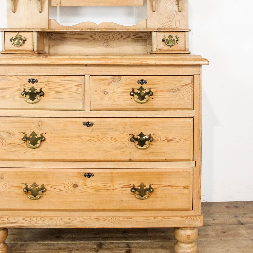 An antique pine dressing chest featuring an upper swivel mirror, small gallery drawers, two short drawers over two long drawers, and turned feet. View IV
