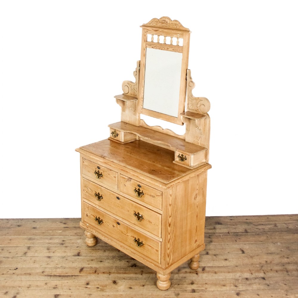 An antique pine dressing chest featuring an upper swivel mirror, small gallery drawers, two short drawers over two long drawers, and turned feet. View V