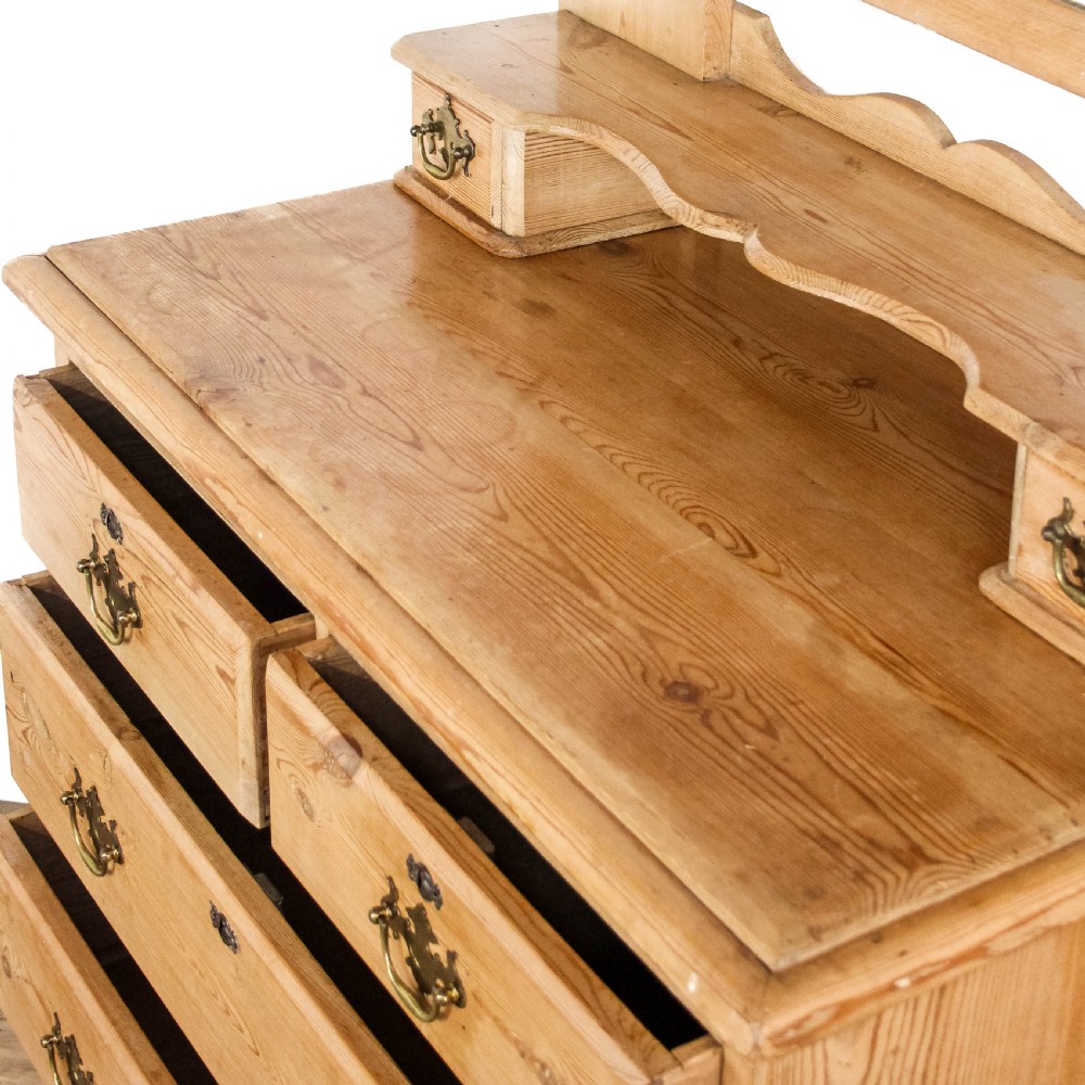 An antique pine dressing chest featuring an upper swivel mirror, small gallery drawers, two short drawers over two long drawers, and turned feet. View VI