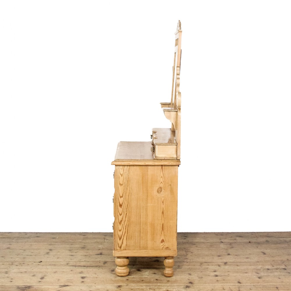 An antique pine dressing chest featuring an upper swivel mirror, small gallery drawers, two short drawers over two long drawers, and turned feet. View VII