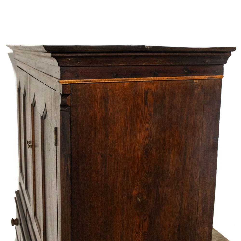 An early nineteenth-century dark oak Welsh press cupboard with two arched fielded panel doors above a base of five drawers on bracket feet. View VIII