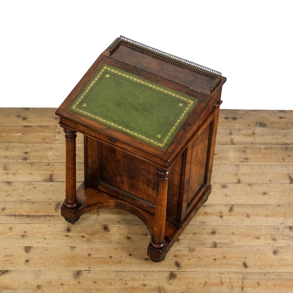 An early 19th-century mahogany davenport desk featuring a green leather writing slope, brass gallery top rail, turned front support columns, and an integrated drawer with a key. View VII