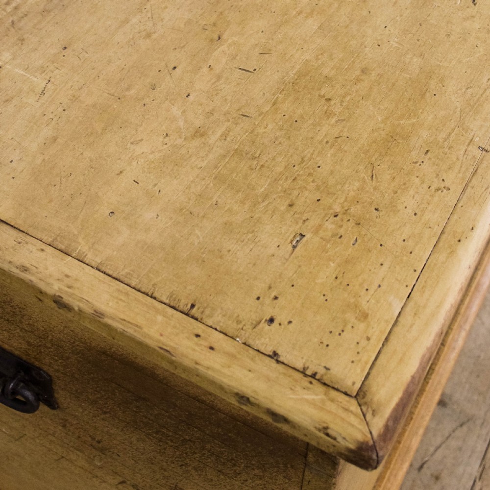 A rectangular antique pine blanket box featuring visible dovetail joinery, a brass keyhole escutcheon, and a shaped plinth base. View III
