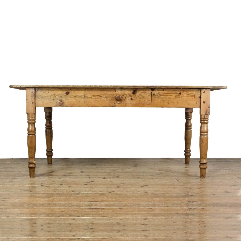 A large antique pine farmhouse kitchen table featuring a plank top, turned legs, and a single frieze drawer with a wooden knob. View II