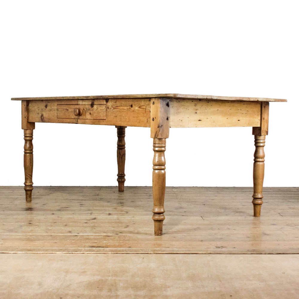 A large antique pine farmhouse kitchen table featuring a plank top, turned legs, and a single frieze drawer with a wooden knob. View IV