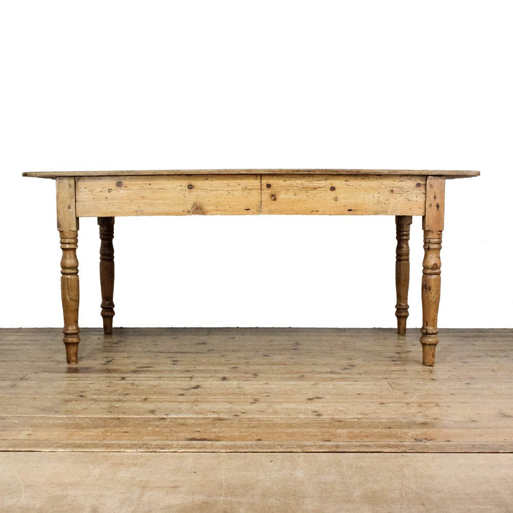 A large antique pine farmhouse kitchen table featuring a plank top, turned legs, and a single frieze drawer with a wooden knob. View V