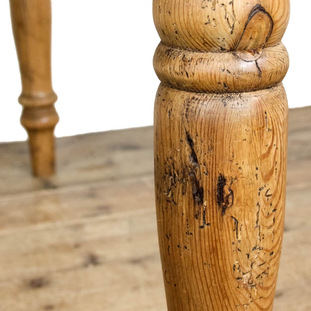 A large antique pine farmhouse kitchen table featuring a plank top, turned legs, and a single frieze drawer with a wooden knob. View VII